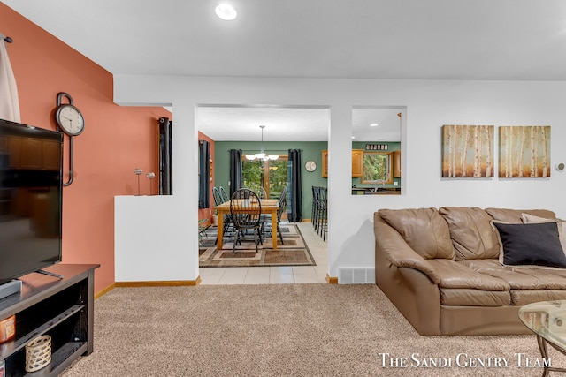 carpeted living room featuring a notable chandelier