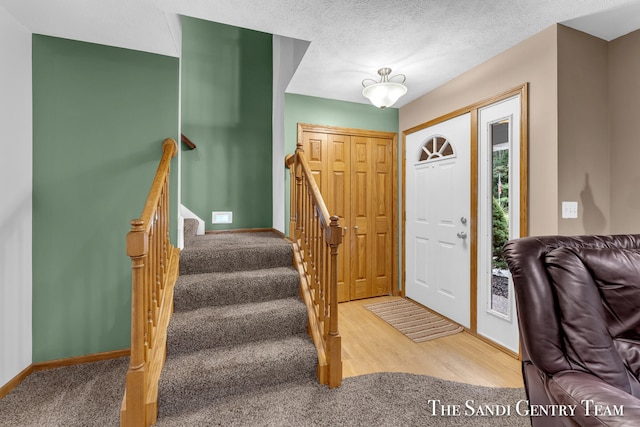 entryway featuring carpet and a textured ceiling