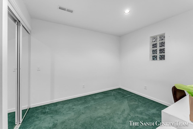 unfurnished bedroom with dark carpet and a closet