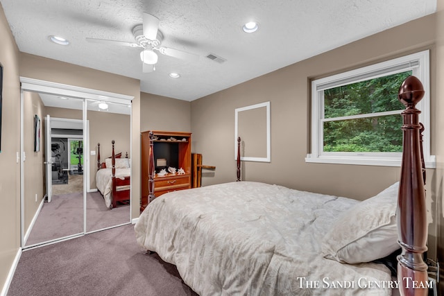 carpeted bedroom featuring a textured ceiling, a closet, and ceiling fan