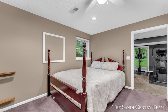 carpeted bedroom featuring ceiling fan and a textured ceiling