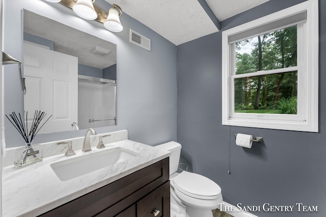 bathroom with vanity, a textured ceiling, and toilet