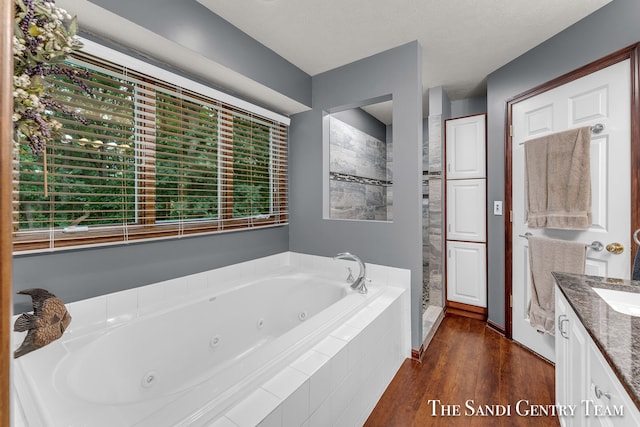 bathroom featuring hardwood / wood-style floors, vanity, a textured ceiling, and separate shower and tub