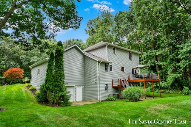 back of house with a lawn, a wooden deck, and a garage