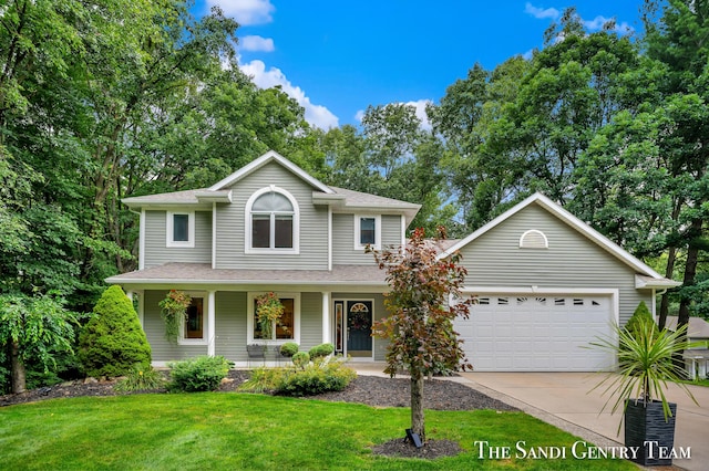 view of property featuring a front lawn, a porch, and a garage