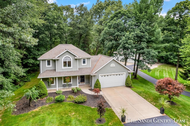 view of front of property with a front yard, a porch, and a garage