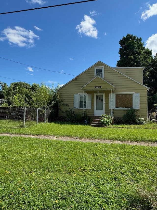 bungalow-style house with entry steps, a front lawn, and fence