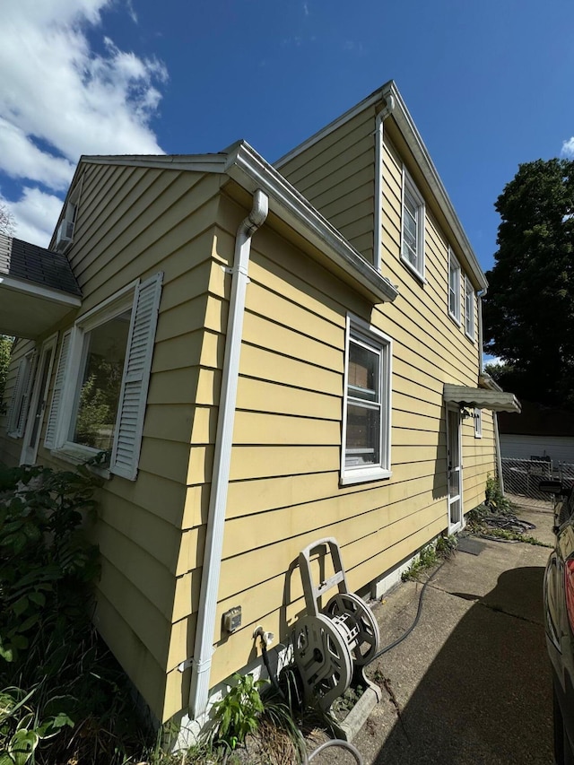 view of side of home featuring fence