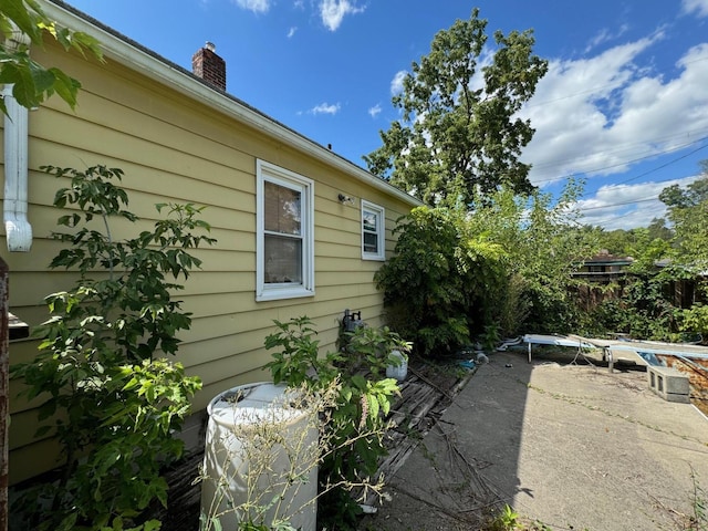 view of side of property with a chimney and a patio