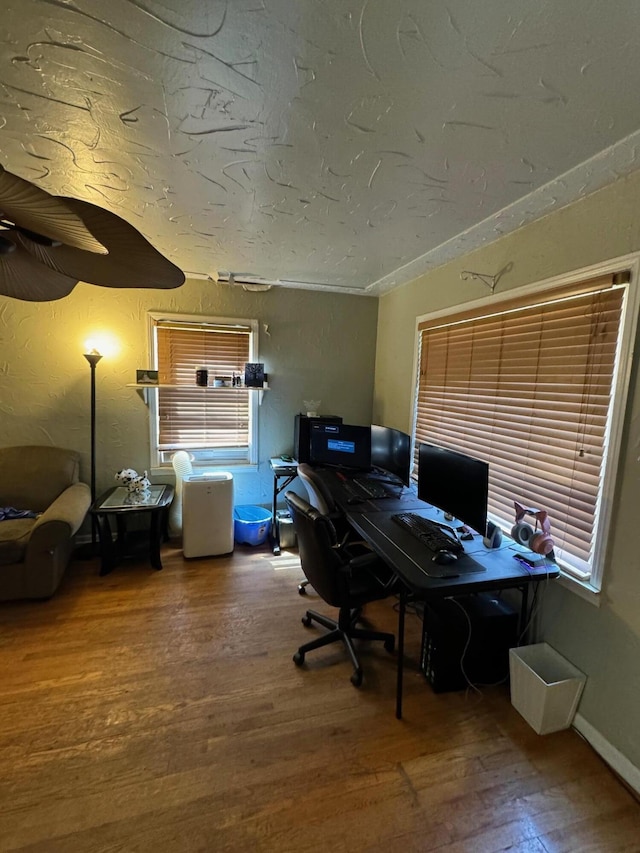 office space featuring lofted ceiling, wood finished floors, a textured wall, and a textured ceiling