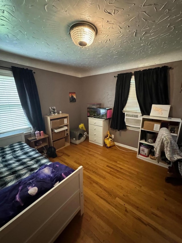 bedroom featuring wood finished floors and a textured ceiling