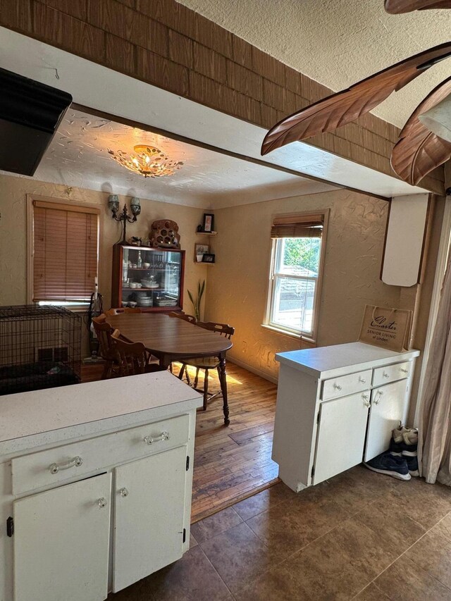 kitchen featuring a textured ceiling, hardwood / wood-style floors, and white cabinets