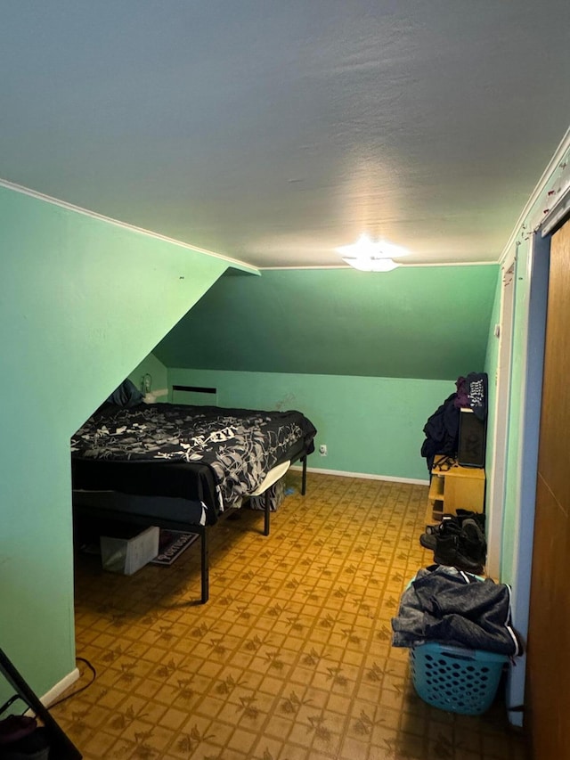 bedroom featuring lofted ceiling, light floors, and baseboards