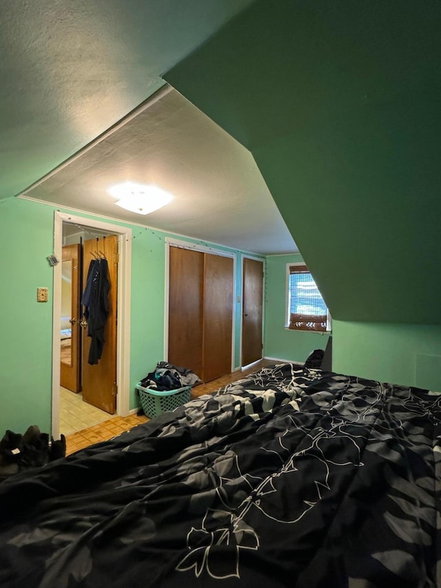 bedroom with a textured ceiling and vaulted ceiling