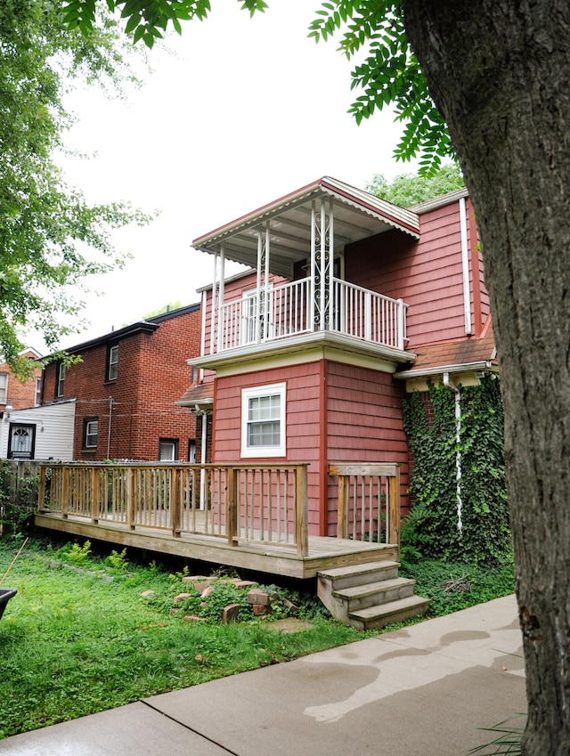 view of front of home featuring a balcony and a front yard