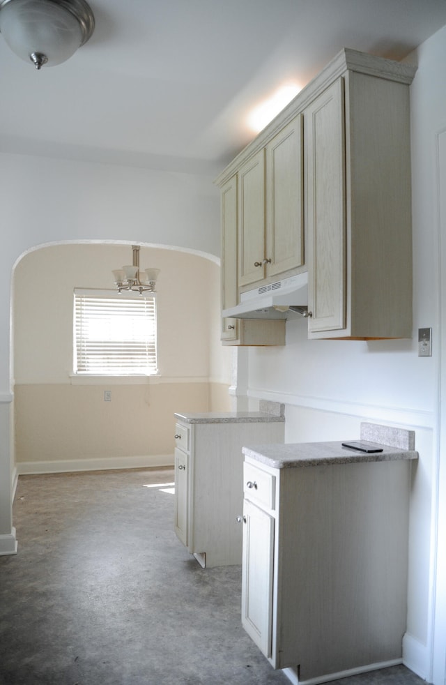 kitchen with a chandelier and light stone countertops