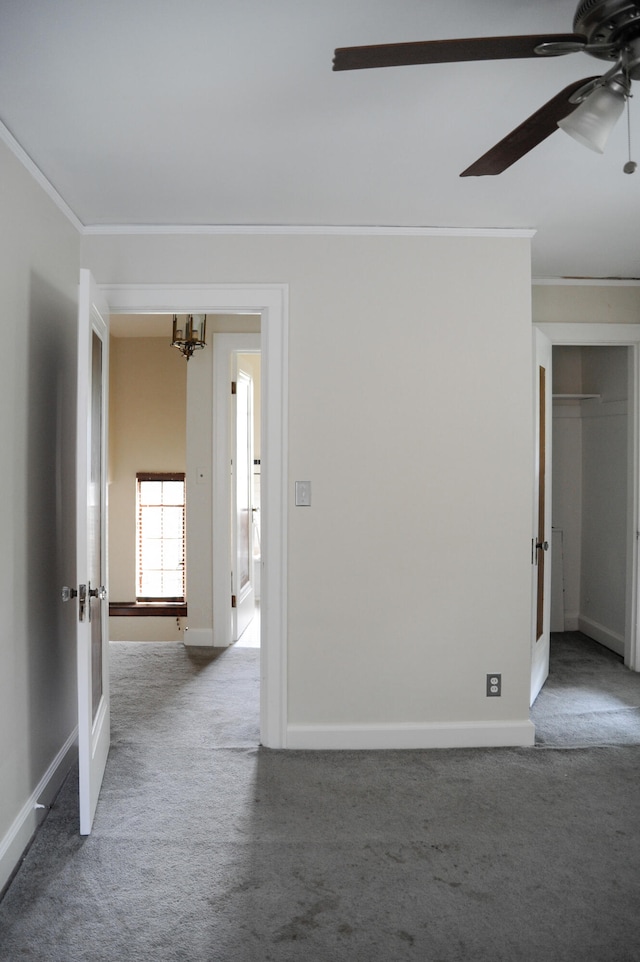 carpeted spare room featuring ceiling fan and crown molding