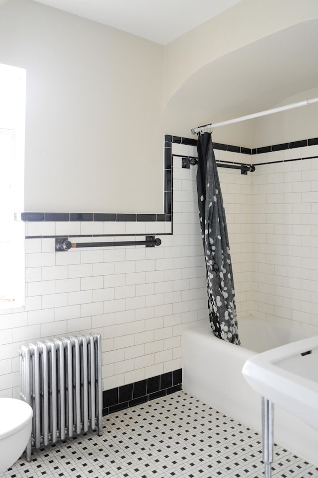 bathroom with shower / tub combo, tile walls, radiator, and tile patterned flooring