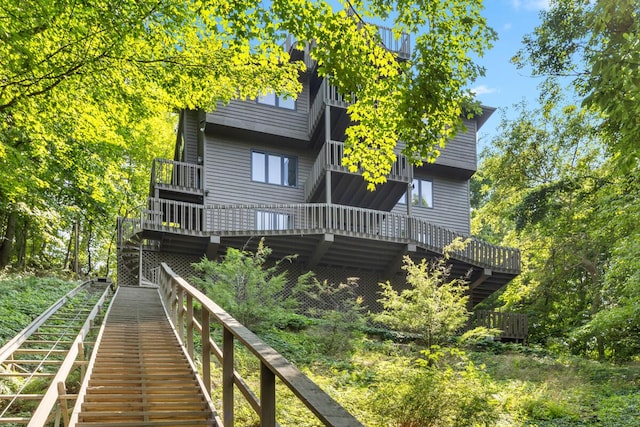 rear view of house featuring stairway and a wooden deck