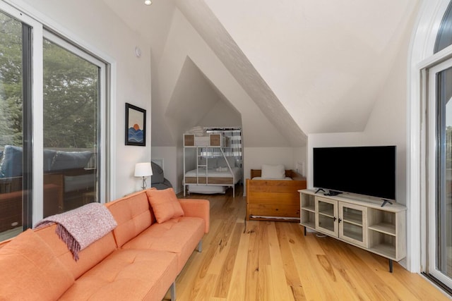 living area with light wood-style floors and vaulted ceiling