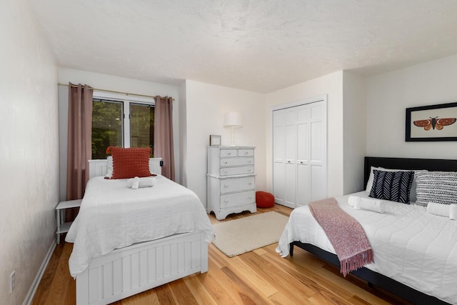 bedroom with a closet, baseboards, and wood finished floors