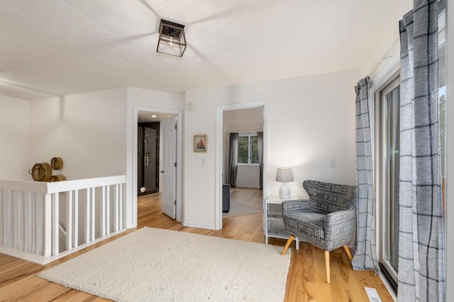 living area featuring baseboards and light wood-style flooring