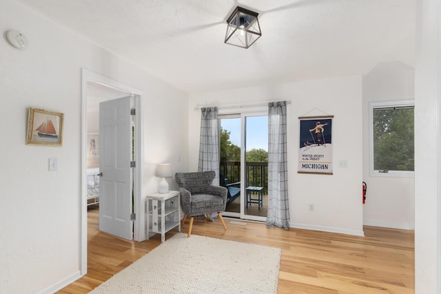 sitting room featuring baseboards and light wood-type flooring