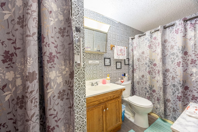 full bath featuring toilet, a textured ceiling, and vanity