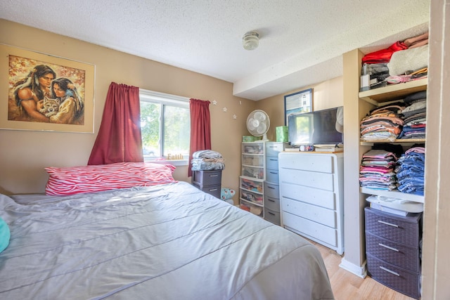 bedroom with a textured ceiling and light wood-style flooring