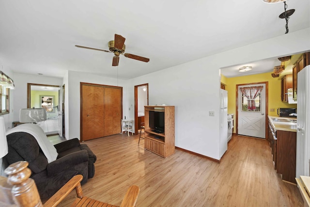 living room featuring sink, ceiling fan, and light hardwood / wood-style floors