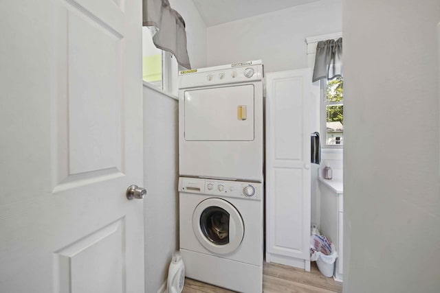 washroom featuring light wood-type flooring and stacked washing maching and dryer