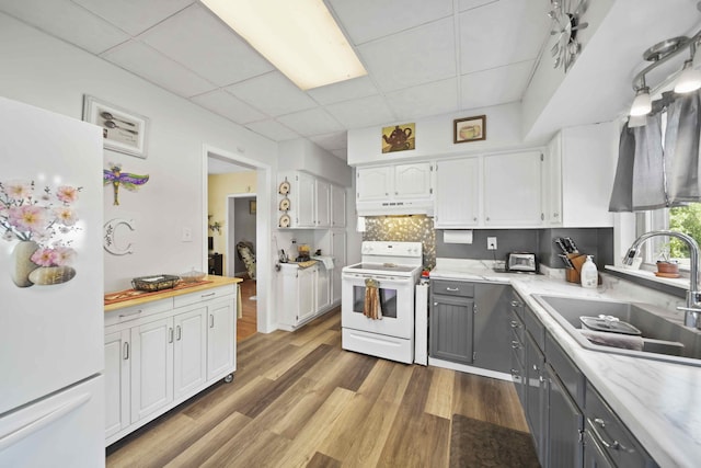 kitchen featuring white appliances, gray cabinets, a paneled ceiling, white cabinetry, and wood-type flooring