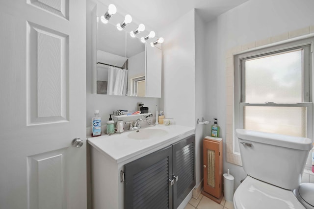 bathroom featuring toilet, vanity, and tile patterned flooring