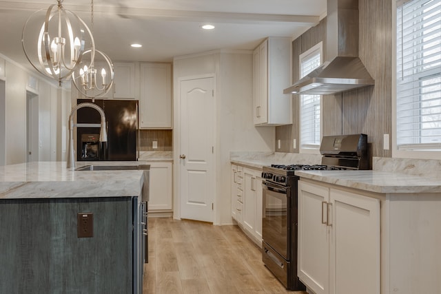 kitchen with wall chimney exhaust hood, white cabinets, black appliances, and pendant lighting