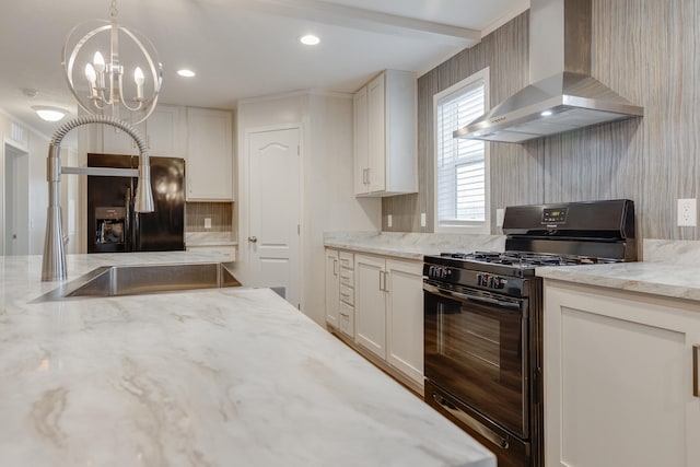 kitchen with black appliances, light stone counters, hanging light fixtures, and wall chimney range hood