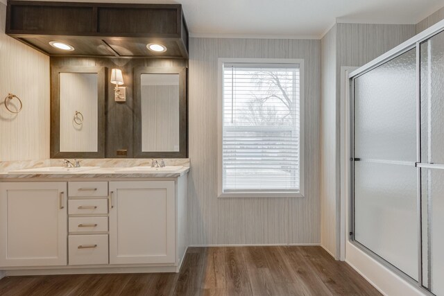 bathroom with hardwood / wood-style flooring, dual vanity, and an enclosed shower