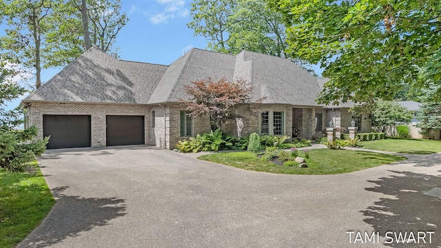 view of front facade with a front lawn, a garage, brick siding, and concrete driveway