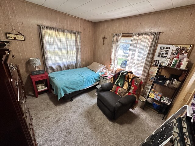 carpeted bedroom with wooden walls