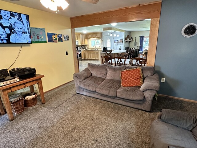 carpeted living room featuring sink and ceiling fan