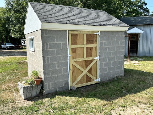 view of outbuilding featuring a lawn