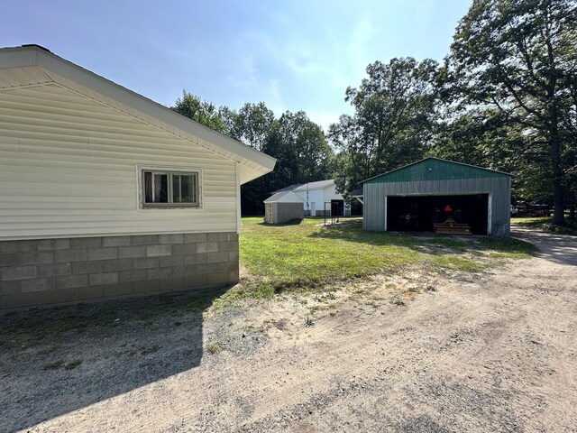 view of yard with a garage and an outbuilding