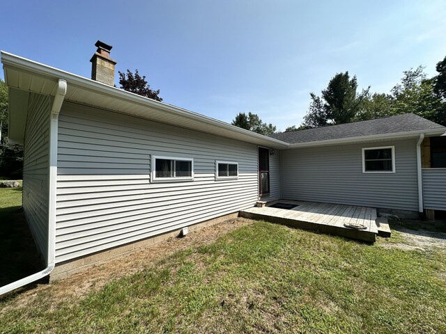 rear view of property with a yard and a wooden deck