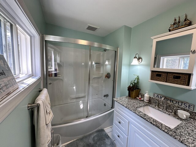 bathroom featuring enclosed tub / shower combo and vanity