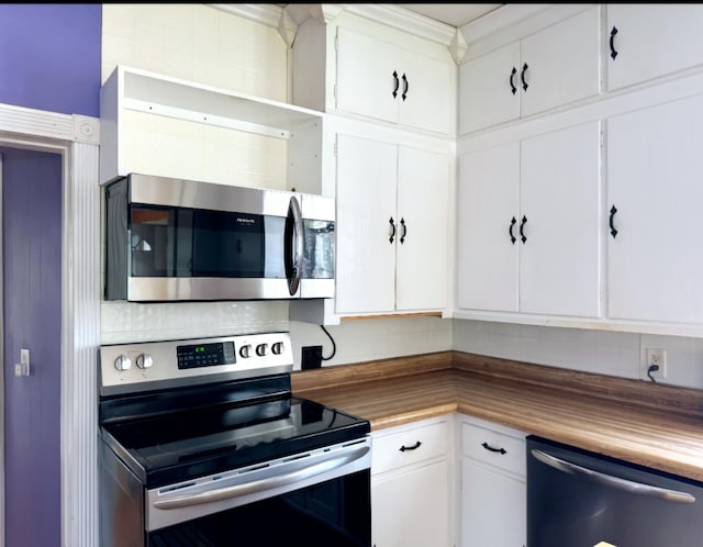 kitchen with stainless steel appliances, backsplash, wood counters, and white cabinetry