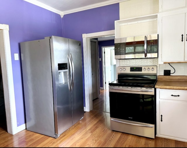 kitchen with ornamental molding, white cabinetry, stainless steel appliances, light wood finished floors, and decorative backsplash