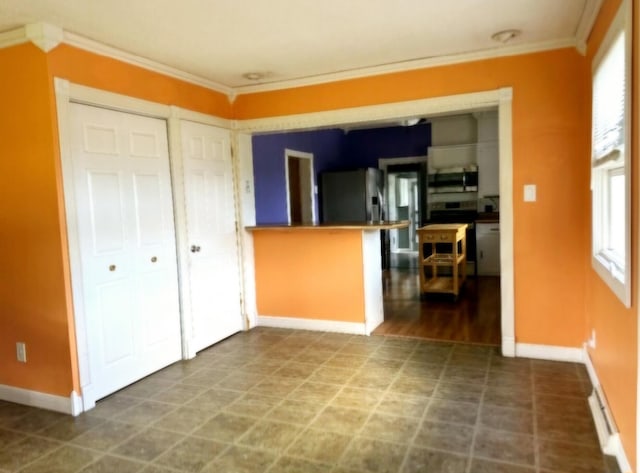 kitchen with appliances with stainless steel finishes, baseboards, and ornamental molding