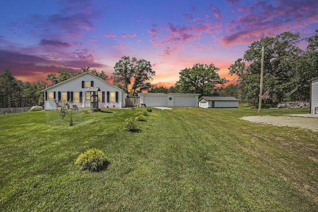 view of front facade featuring a garage, an outdoor structure, and a lawn