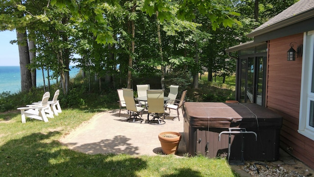 view of patio featuring a hot tub and a water view