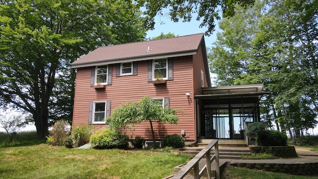 view of side of home featuring a lawn and a sunroom