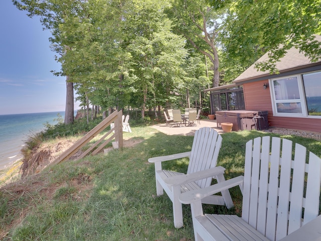 view of yard featuring a hot tub, a patio, and a water view